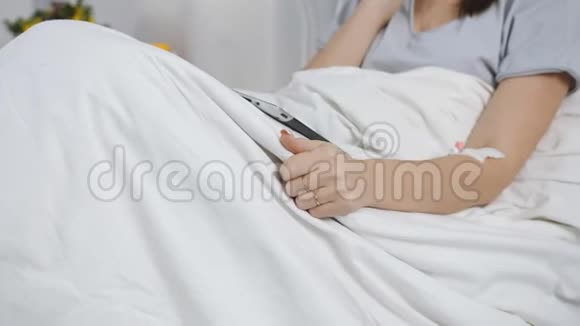 医院病床上使用移动电话的女性病人视频的预览图