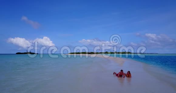 V08519两个年轻人浪漫的一对日光浴无人驾驶飞机在沙滩上飞行沙滩上白沙美丽视频的预览图