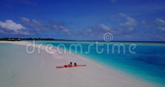 V085342年轻人浪漫情侣在白色沙滩上享受无人机空中飞行的日光浴视频的预览图