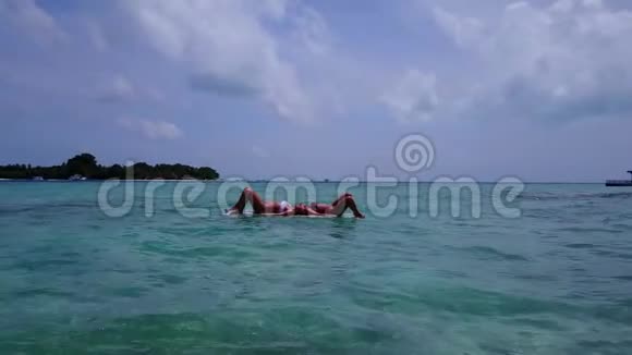 V082082个漂亮的年轻女孩在冲浪板上可以在温暖的蓝色海水中鸟瞰视频的预览图