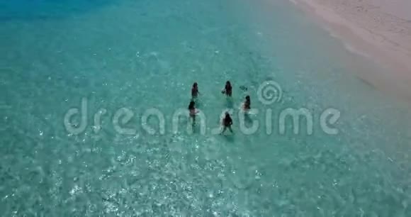 V08440组5名年轻女子在阳光岛白沙滩碧海天水上进行空中无人机球拍视频的预览图