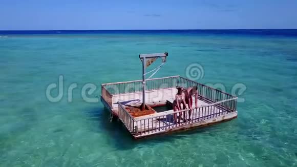 V08597两位年轻人在美丽的碧蓝的海水中在浮舟上享受浪漫的日光浴视频的预览图