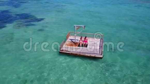 V08585两个年轻人在美丽的碧蓝色海水中在浮舟上享受浪漫的日光浴视频的预览图