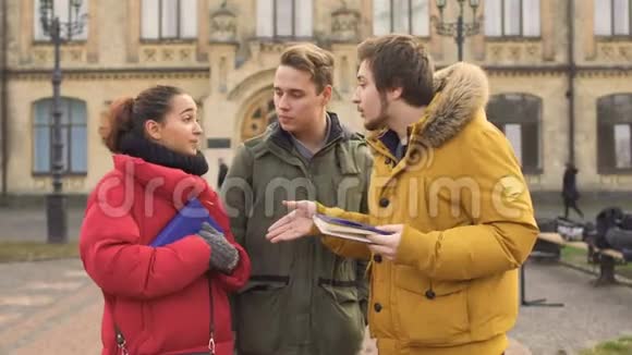 三位年轻学生在大学附近交谈视频的预览图