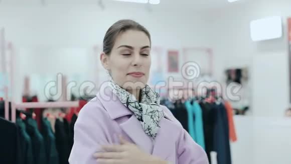 年轻苗条的女士穿着一件外套女人在镜子前购物和检查粉红色外套风格和风格视频的预览图