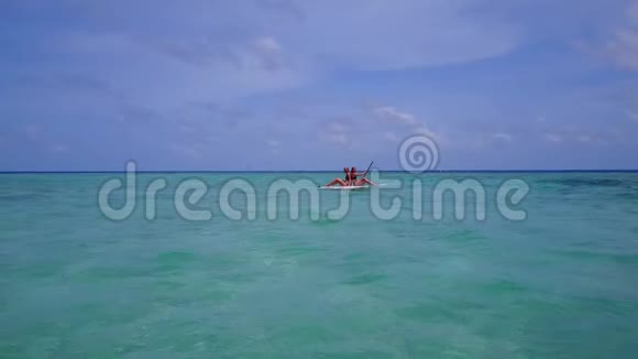 V08391两个漂亮的年轻女孩坐在冲浪板上在温暖的蓝色海水中鸟瞰天空视频的预览图