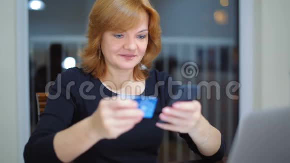 成年女士使用智能手机和信用卡在家支付费用视频的预览图