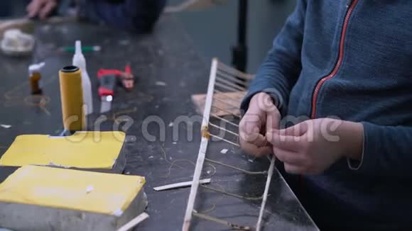 近距离男孩的手拼螺纹飞机模型机笼视频的预览图