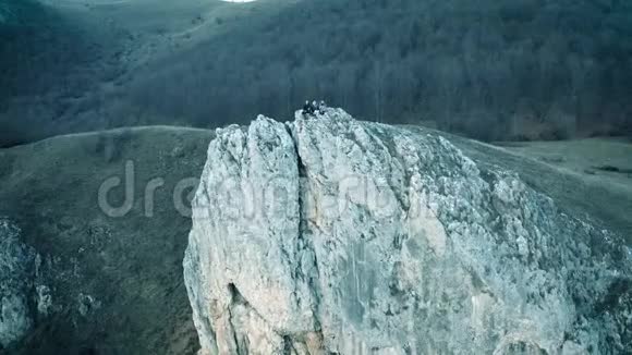 无人驾驶飞机空中飞行坐在悬崖上的年轻人视频的预览图