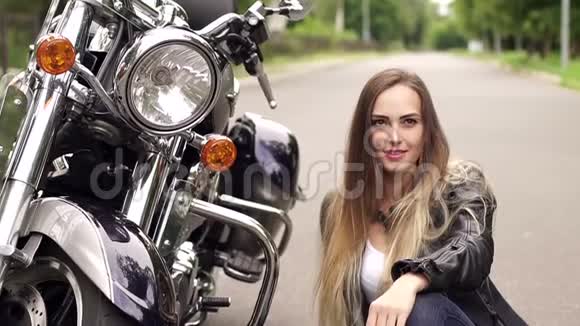 摩托车附近穿皮夹克的女孩画像视频的预览图