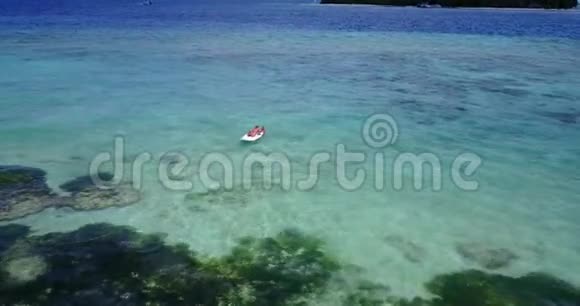 V08357两个漂亮的年轻女孩坐在冲浪板桨板上在温暖的蓝色海水中鸟瞰视频的预览图