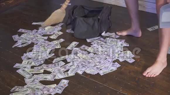 扫帚在地板上用垃圾桶扫一扫钱意外财富概念视频的预览图