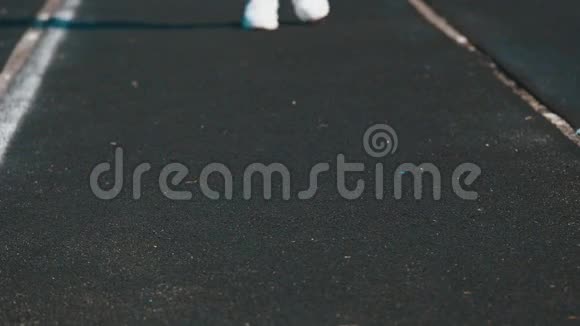 体育运动运动的年轻女子穿着白色运动鞋在跑道上奔跑视频的预览图