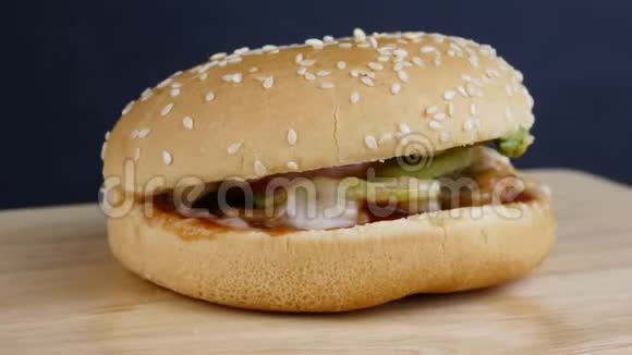 新鲜开胃的汉堡撒上芝麻在黑色背景上旋转视频的预览图
