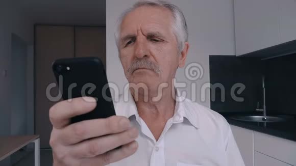 家庭厨房使用智能手机的胡子老人画像视频的预览图