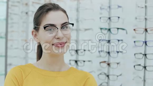 保健视力和视力的概念在光学商店戴眼镜的漂亮女人商店货架的背景视频的预览图