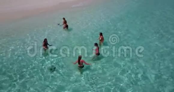 V08439组5名年轻女子在阳光岛白沙滩碧海天水上进行空中无人机球拍视频的预览图