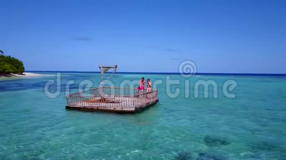 V08555两个年轻人在美丽的碧蓝色海水中在浮舟上享受浪漫的日光浴视频的预览图