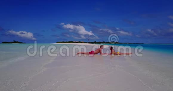 V08525两个年轻人浪漫的一对日光浴无人驾驶飞机在沙滩上飞行沙滩上白沙美丽视频的预览图