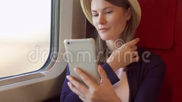 年轻的旅行者乘坐高速国际列车使用智能手机坐火车的女人自拍视频的预览图