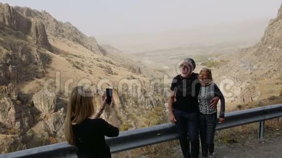 女儿通过手机拍照她的高级父母在山区度假旅行在公路站幸福家庭视频的预览图