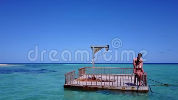 v08569两个年轻人在美丽的碧蓝的海水中在浮舟上享受浪漫的日光浴视频的预览图