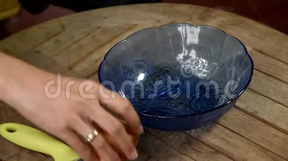 录像片段用不锈钢刀将鸡蛋壳打碎然后放入蓝色玻璃碗中视频的预览图