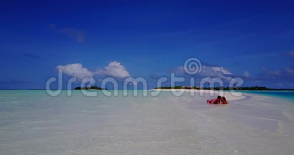 V08546两个年轻人浪漫的情侣日光浴无人驾驶飞机在白沙和美丽的海滩上飞行视频的预览图