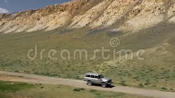 沙迹路上狩猎车辆行驶的景观在4x4路附近沿砾石小径行驶视频的预览图