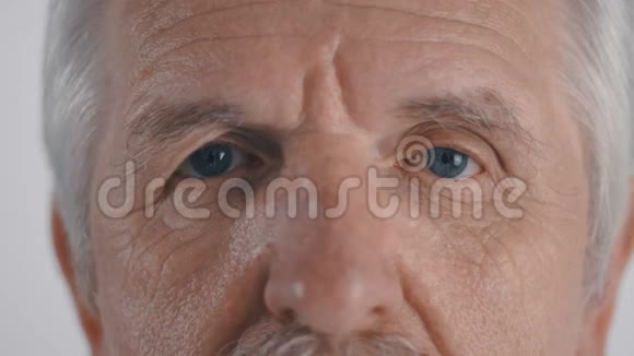 胡子老人的特写镜头在白色背景下看着镜头视频的预览图
