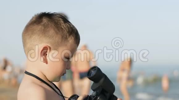 小白种人男孩从另一边的望远镜里看视频的预览图