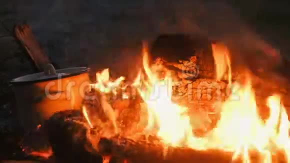 食物是在锅中的篝火上煮熟的煤与树枝翻过来特写镜头视频的预览图