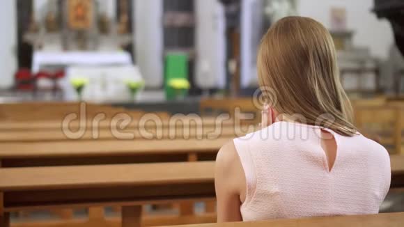 年轻虔诚的宗教妇女在天主教会祈祷欧洲大教堂虔诚的天主教徒视频的预览图