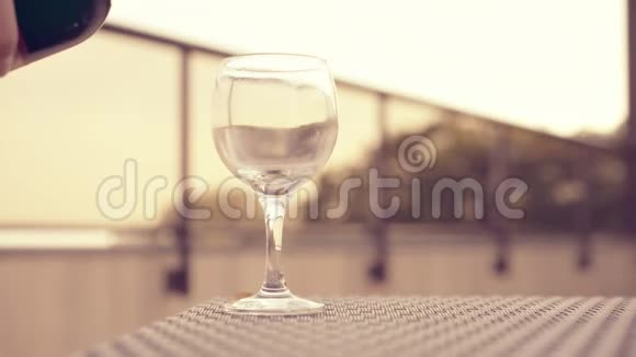 红酒倒进玻璃杯里有小桌子和玻璃栅栏的酒厂屋顶背景在软焦点4kUHD视频的预览图
