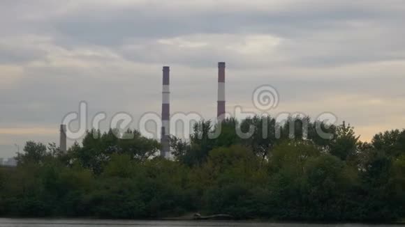 从船上看到大型工业管道上的水日落时分的工厂烟囱环境污染视频的预览图