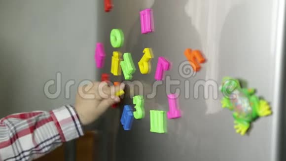 小保姆带着一个小男孩学习磁铁上的字母视频的预览图