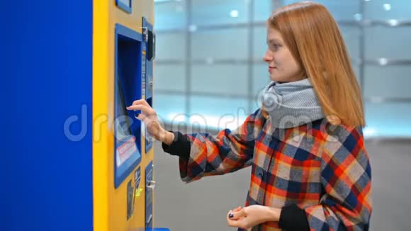 年轻女士正在用自动售货机买票用硬币付款视频的预览图