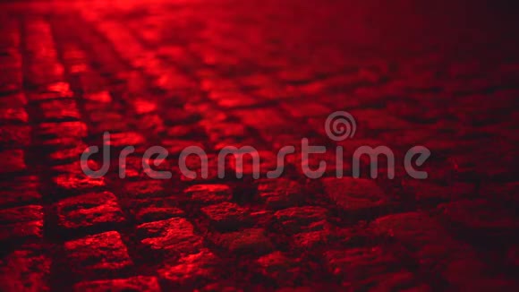 夜晚红色的鹅卵石铺砌的街道照亮了潮湿的环境视频的预览图