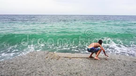 在海滩上玩得开心动作慢夏天在卵石海岸的家人视频的预览图