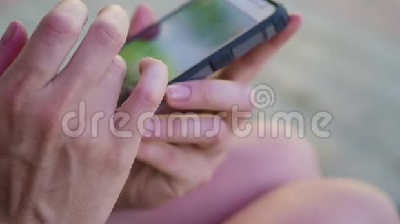 在城市公园户外使用触摸屏手机的特写女性手视频的预览图