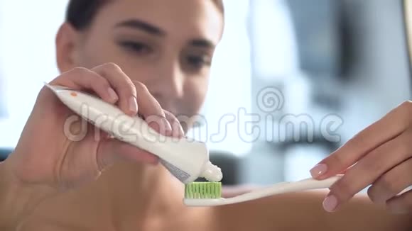 牙齿卫生涂牙膏在牙刷上的女人视频的预览图