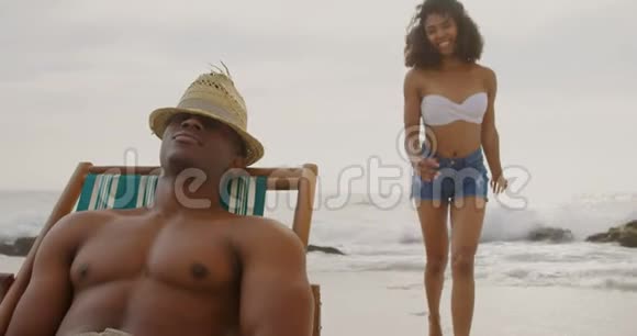 在海滩上一起玩的非裔美国人夫妇的正面景色视频的预览图