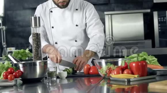 厨师在厨房做新鲜沙拉特写雄性手切黄瓜视频的预览图