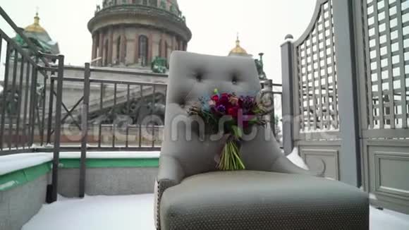 婚礼新娘花束在冬天雪天的露台上的椅子上视频的预览图