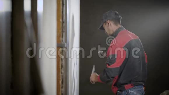 一个专业的建筑工人从事捣碎瓷砖附近的接缝以便做一个设计墙视频的预览图