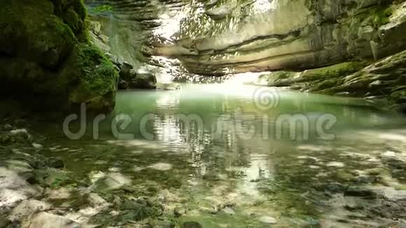 森林中古老岩石之间的小湖视频的预览图