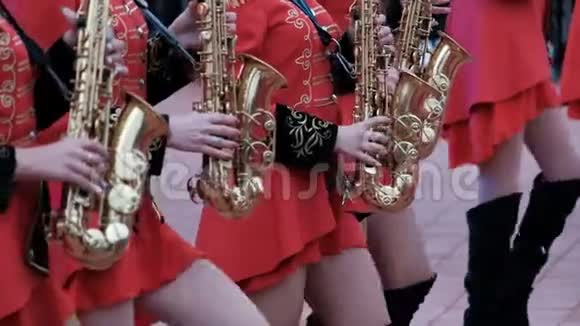 穿着红色衣服和黑色靴子的女孩玩萨克斯风特写镜头科斯塔奈铜管乐队视频的预览图