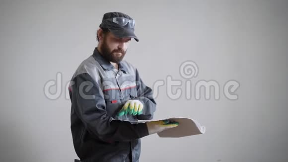 一名戴手套的成年男子的肖像一名建筑工人手中拿着修理公寓的图纸视频的预览图