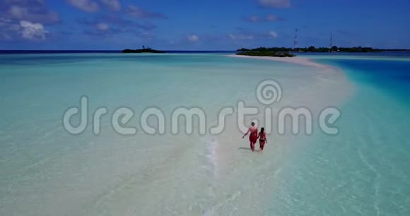 两个两个人浪漫的年轻人一对手牵手在热带地区的无人机空中飞行视频的预览图