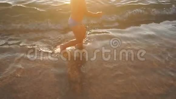 日落时小男孩在海滩上玩得很开心慢动作视频的预览图